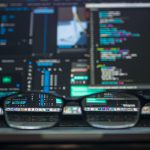 lunettes devant un écran contenant du code informatique