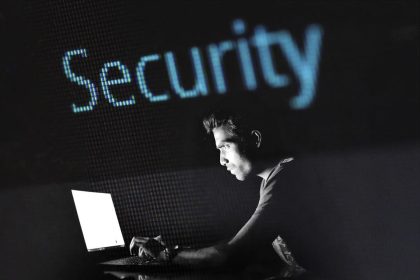 un homme devant un écran d'ordinateur surmonté du mot "sécurité" en anglais.